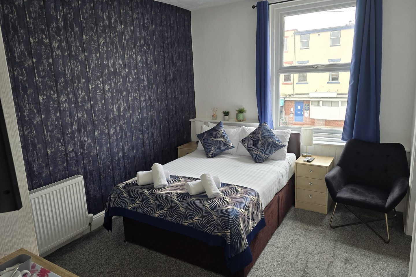 Family Suite double room with a dark feature wall, armchair and window